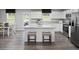 Bright kitchen with island seating, white cabinets, stainless steel appliances, and eat-in dining space at 294 N Coral Bells Way, Four Oaks, NC 27524