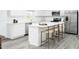 Bright kitchen with white cabinets, stainless steel appliances, and a large island with seating at 294 N Coral Bells Way, Four Oaks, NC 27524