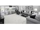 Open-concept living room featuring neutral tones, modern furniture, and a view into the kitchen at 294 N Coral Bells Way, Four Oaks, NC 27524