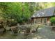 Backyard features stone fire pit with chairs and rustic cabin at 300 Rabbit Run, Pittsboro, NC 27312