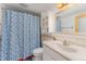 Bathroom offers a single sink vanity, toilet and bathtub with blue floral shower curtain at 300 Rabbit Run, Pittsboro, NC 27312