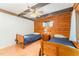 Charming bedroom featuring wood paneled walls, ceiling fan, and twin beds at 300 Rabbit Run, Pittsboro, NC 27312