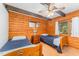 Charming bedroom featuring wood paneled walls, ceiling fan, and twin beds at 300 Rabbit Run, Pittsboro, NC 27312