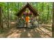 Cabin exterior with a wooden porch and lush forest surroundings at 300 Rabbit Run, Pittsboro, NC 27312