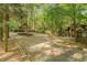 A long gravel driveway through a mature hardwood forest on a sunny day at 300 Rabbit Run, Pittsboro, NC 27312