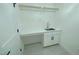 Bright laundry room with white cabinets, quartz countertop, sink, and gray tile flooring at 3004 Eden Harbor Ct, Raleigh, NC 27613