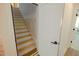 Unfinished wooden staircase with white walls and trim and an open door at 3004 Eden Harbor Ct, Raleigh, NC 27613