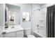Bright bathroom featuring a shower-tub combination, single vanity, and a stylish, framed art piece on a calming blue wall at 302 N Coral Bells Way, Four Oaks, NC 27524