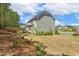 Backyard features a two-story home, lush landscaping, and beautiful blue skies at 304 Channel Cove Dr, Holly Springs, NC 27540
