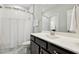 White bathroom featuring a walk-in shower with white tiling and a dark brown vanity at 304 Channel Cove Dr, Holly Springs, NC 27540