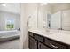 Bathroom vanity with dark brown cabinets, white counter, and a view into the bedroom at 304 Channel Cove Dr, Holly Springs, NC 27540