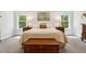 Bright bedroom featuring large windows, soft carpet, and a wooden chest at 304 Channel Cove Dr, Holly Springs, NC 27540
