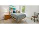 Neutral bedroom with a twin bed, wooden bookshelf, and a window overlooking the trees at 304 Channel Cove Dr, Holly Springs, NC 27540