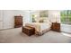 Comfortable bedroom featuring large windows, soft carpet, and a wooden chest at 304 Channel Cove Dr, Holly Springs, NC 27540