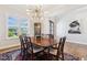 Elegant dining room with a large table set with eight chairs, hardwood floors, and a hutch at 304 Channel Cove Dr, Holly Springs, NC 27540