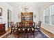 Elegant dining room with a large table set with eight chairs, hardwood floors, and a hutch at 304 Channel Cove Dr, Holly Springs, NC 27540