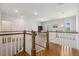 Bright upstairs hallway overlooking the stairs, with hardwood floors and white railings at 304 Channel Cove Dr, Holly Springs, NC 27540