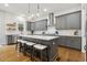 Stylish kitchen with gray cabinets, subway tile backsplash, a large island, and pendant lighting at 304 Channel Cove Dr, Holly Springs, NC 27540