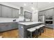 Well-equipped kitchen features a central island, stainless steel appliances, and custom gray cabinetry at 304 Channel Cove Dr, Holly Springs, NC 27540