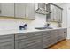 Modern kitchen features gray cabinets with gold hardware, subway tile, and a gas cooktop at 304 Channel Cove Dr, Holly Springs, NC 27540