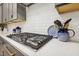 Modern kitchen features a gas cooktop, custom cabinetry, and quartz countertops at 304 Channel Cove Dr, Holly Springs, NC 27540