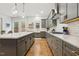 Light-filled kitchen featuring gray cabinets, quartz counters, a gas range, and access to outdoor space at 304 Channel Cove Dr, Holly Springs, NC 27540