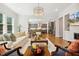 Open-concept living room featuring a chandelier, hardwood floors, and access to the kitchen at 304 Channel Cove Dr, Holly Springs, NC 27540