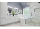 Bright bathroom showcasing a double vanity, soaking tub, and glass enclosed shower with marble tile at 308 Hassellwood Dr, Cary, NC 27518
