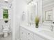 Bright bathroom featuring a double vanity, decorative mirror, and bright lighting at 308 Hassellwood Dr, Cary, NC 27518