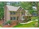 Stately two-story brick home featuring manicured lawn, lush landscaping, and elegant architectural details at 308 Hassellwood Dr, Cary, NC 27518