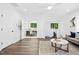 Open-concept living room with hardwood floors, neutral paint, and natural light spilling into adjacent office space at 308 Hassellwood Dr, Cary, NC 27518
