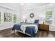 Light filled main bedroom features a large bed, two windows, modern decor, and hardwood floors at 308 Hassellwood Dr, Cary, NC 27518