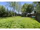 Large backyard with a modern outbuilding, lush green lawn, and mature trees, perfect for outdoor activities at 310 Georgetown Rd, Raleigh, NC 27608