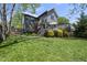 Spacious backyard featuring a lush lawn, gray two-story house, and an inviting deck with an umbrella at 310 Georgetown Rd, Raleigh, NC 27608