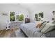 Sunlit bedroom with a large bed, neutral decor, wood floors, and ample natural light from two large windows at 310 Georgetown Rd, Raleigh, NC 27608
