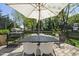 Outdoor dining set beneath a large umbrella, overlooking the backyard at 310 Georgetown Rd, Raleigh, NC 27608