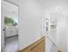 Bright hallway featuring wood floors, white walls, and views into the kitchen and other living spaces at 310 Georgetown Rd, Raleigh, NC 27608