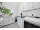 Bright laundry room featuring front loading washer and dryer, ample cabinets and built-in sink at 310 Georgetown Rd, Raleigh, NC 27608