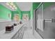 Green bathroom has shower, toilet, and large vanity featuring plentiful storage and counter space at 3126 Truitt Dr, Burlington, NC 27215