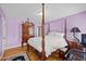 This bedroom features a four-poster bed, an ornate chest of drawers, and beautiful hardwood flooring at 3126 Truitt Dr, Burlington, NC 27215