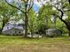 Spacious backyard with mature trees, outbuilding, and a basketball court, perfect for outdoor activities at 330 W King St, Hillsborough, NC 27278
