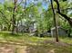Serene backyard view featuring a charming home, storage shed, and lush greenery at 330 W King St, Hillsborough, NC 27278