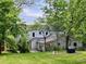 A lush backyard with a well-maintained lawn, mature trees, and a charming traditional-style house at 330 W King St, Hillsborough, NC 27278