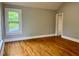 Bright bedroom with hardwood floors, one bright window, and neutral wall color offers a clean and inviting space at 330 W King St, Hillsborough, NC 27278