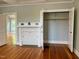 Bedroom with hardwood floors, built-in storage cabinets and shelving, and closet with hanging rods and shelves at 330 W King St, Hillsborough, NC 27278
