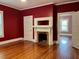 Cozy bedroom with beautiful hardwood floors, fireplace and bright red paint, creating a warm atmosphere at 330 W King St, Hillsborough, NC 27278