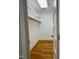 Walk-in closet featuring a clothing rod, upper shelf, hardwood floors, and natural light from the skylight at 330 W King St, Hillsborough, NC 27278