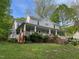 Exterior home view featuring the long porch and complemented by a lush green lawn at 330 W King St, Hillsborough, NC 27278