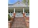 Inviting covered front porch with brick pillars and access to the home's entrance at 330 W King St, Hillsborough, NC 27278