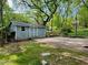 Exterior view of outbuilding, complemented by a basketball court, surrounded by lush greenery and trees at 330 W King St, Hillsborough, NC 27278